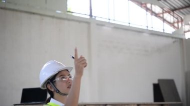 Kadın mühendis hangarı kontrol ederken not alıyor, iş için yeni konum  