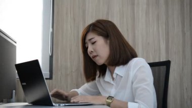 Ofiste çalışırken dizüstü bilgisayarda yazan Asyalı iş kadını.