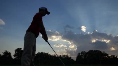 Erkek golfçü çimenli alanda golf oynuyor