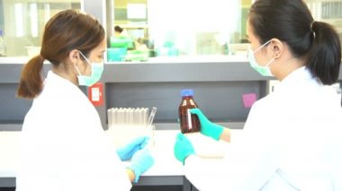İlaç laboratuarında test yapan iki Asyalı kadın bilim adamının yavaş çekimleri. 