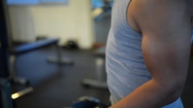 Spor salonundaki kaslı Asyalı adamın portresi vücut ağırlığı egzersizi.