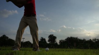 Erkek golfçü çimenli alanda golf oynuyor