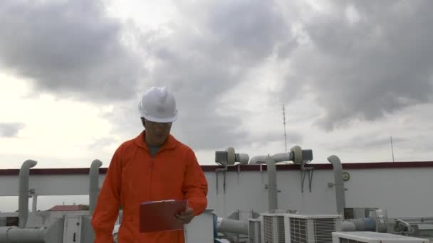 クリップボードとラジオのセット歩くと植物の屋根をチェックする男性エンジニア検査官 — ストック動画