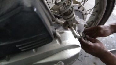 Motosiklet tamir eden adama yaklaş. 
