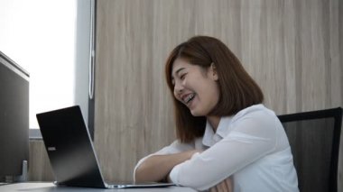 Asyalı iş kadını iş yerinde gülüyor