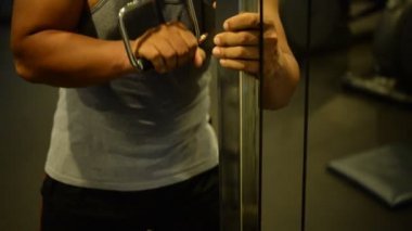 Spor salonundaki kaslı Asyalı adamın portresi vücut ağırlığı egzersizi.