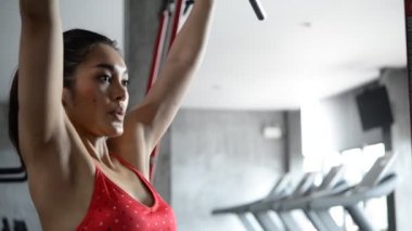 Spor salonunda antrenman yapan Asyalı sporcu kadın, egzersiz videosu.