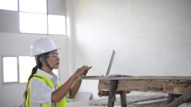 Hangarı kontrol ederken dizüstü bilgisayarda yazan kadın mühendis, iş için yeni konum  