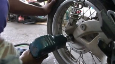 Motosiklet tamir eden adama yaklaş. 