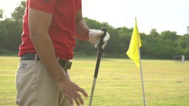 Erkek golfçü çimenli alanda golf oynuyor