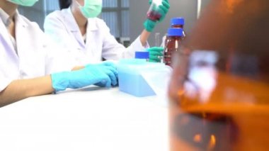 İki Asyalı bilim adamı ilaç laboratuarında test yapıyor. 