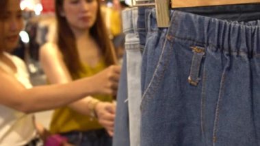 Alışveriş merkezinde kıyafet seçen kadın arkadaşlar, alışveriş konsepti.