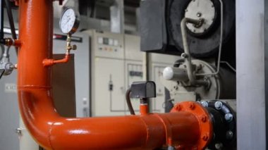 Kazan dairesinde çalışan Asyalı mühendis, ısıtma sistemi ekipmanlarının teknik verilerini kontrol ediyor.