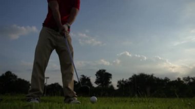 Erkek golfçü çimenli alanda golf oynuyor