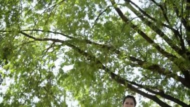 Genç Asyalı kadın gündüz vakti parkta egzersiz yapıyor. 