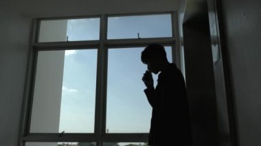 Ofiste akıllı telefon kullanan Asyalı iş adamının silueti 