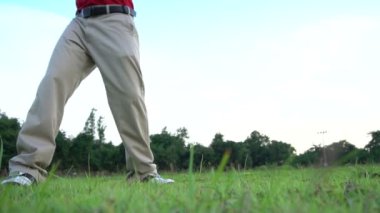 Erkek golfçü çimenli alanda golf oynuyor
