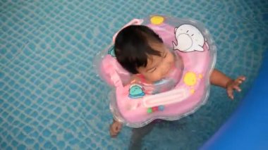 Yüzme havuzunda yüzen küçük tatlı Asyalı kız.