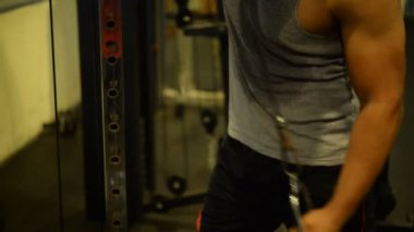 Spor salonundaki kaslı Asyalı adamın portresi vücut ağırlığı egzersizi.