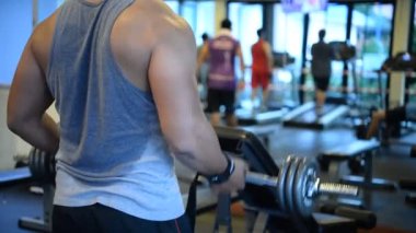 Spor salonundaki kaslı Asyalı adamın portresi vücut ağırlığı egzersizi.