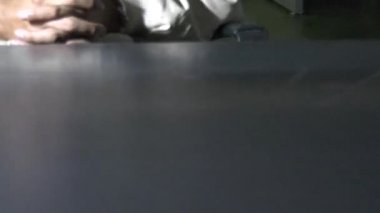 Erkek mahkum karakolda sorgu odasında oturuyor.