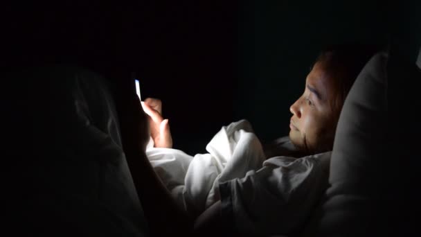 亚洲女人晚上在床上用智能手机玩游戏 — 图库视频影像