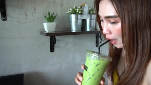 若いアジア人女性がカフェでスムージーを飲む — ストック動画