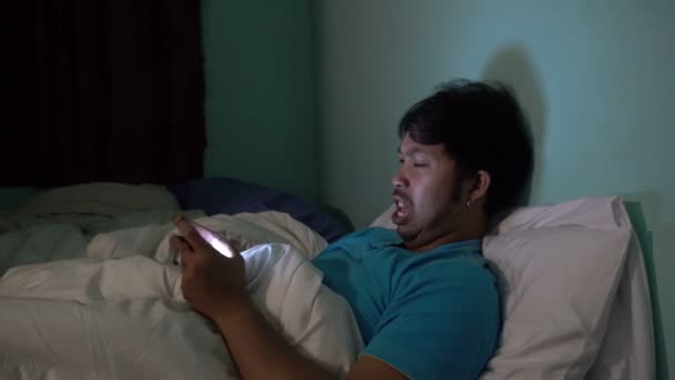 Asian Man Playing Smartphone Bed Nighttime — Stock Video