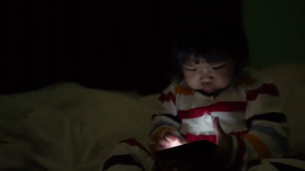 Cute Little Asian Girl Playing Smartphone While Lying Bed — 图库视频影像