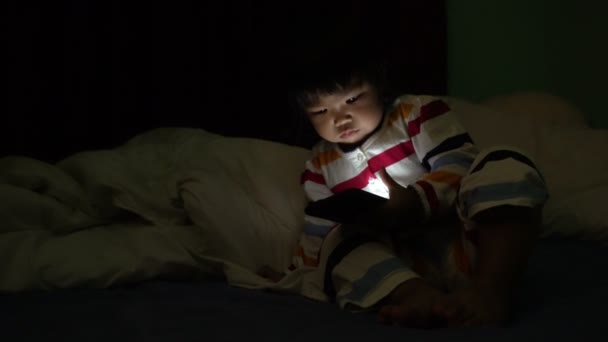 Cute Little Asian Girl Playing Smartphone While Lying Bed — 图库视频影像