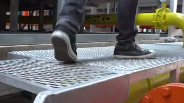 Kazan dairesinde çalışan Asyalı mühendis, ısıtma sistemi ekipmanlarının teknik verilerini kontrol ediyor.