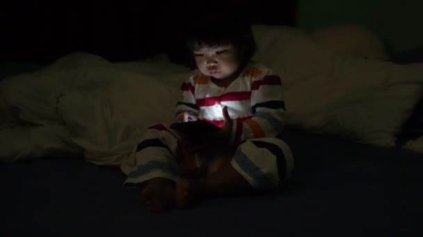 Cute Little Asian Girl Playing Smartphone While Lying Bed — 图库视频影像