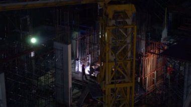 İnşaat halindeki bir binanın silüeti ve inşaat vinçleri. 