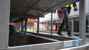 Kazan dairesinde çalışan Asyalı mühendis, ısıtma sistemi ekipmanlarının teknik verilerini kontrol ediyor.