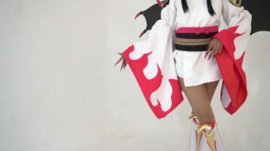 Güzel Asyalı kız kostüm oyunu animasyonu giyer ve beyaz arka planda poz verir.