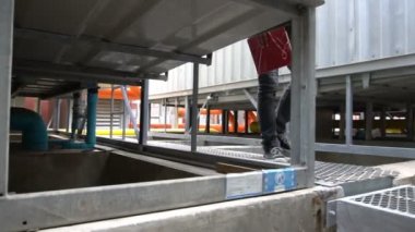 Kazan dairesinde çalışan Asyalı mühendis, ısıtma sistemi ekipmanlarının teknik verilerini kontrol ediyor.