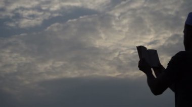 Genç Asyalı Müslüman gün batımında dua ediyor.