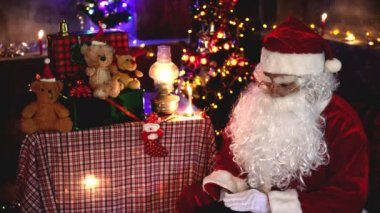 Noel Baba, Noel ağacının yanında çelenkli mektup okuyor. Mutlu tatiller.