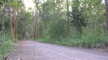 Parkta gündüz koşan Asyalı sporcu kadın.