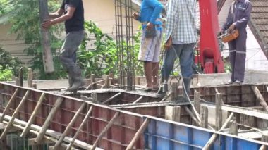 Asyalı işçilerin gündüz nesne inşaatında çalışmalarına bakış