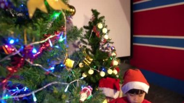 Noel ağacının yanında çocuklu mutlu bir anne, mutlu tatiller.