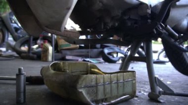 Motosiklet tamir eden adama yaklaş. 