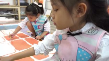Genç Asyalı kızlar sanat okuyor, Taylandlı öğretmenlere resim yapıyor. 