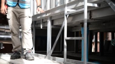 Kazan dairesinde çalışan Asyalı mühendis, ısıtma sistemi ekipmanlarının teknik verilerini kontrol ediyor.