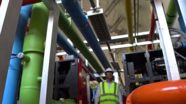 Büyük bir fabrikanın atık su yönetim sisteminde Asya Bakım Mühendisi, Tayland 'daki ısıtma sistemi ekipmanlarının teknik verilerini kontrol ediyor.