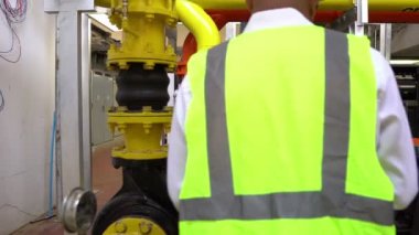 Büyük bir fabrikanın atık su yönetim sisteminde Asya Bakım Mühendisi, Tayland 'daki ısıtma sistemi ekipmanlarının teknik verilerini kontrol ediyor.