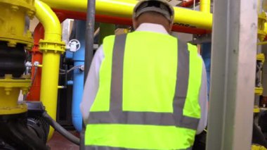 Büyük bir fabrikanın atık su yönetim sisteminde Asya Bakım Mühendisi, Tayland 'daki ısıtma sistemi ekipmanlarının teknik verilerini kontrol ediyor.