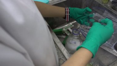 Laboratuvarda çalışan Asyalı bilim adamına yakın çekim. Deneyin sonuçlarını araştıran araştırmacı.