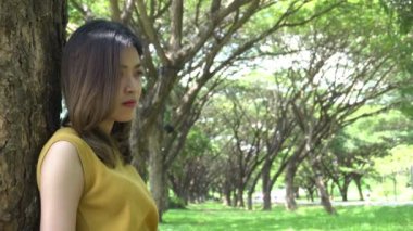 Güzel Taylandlı üzgün kadın gündüz vakti parkta vakit geçiriyor. 