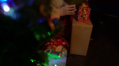 Noel Baba, Noel ağacının yanında çelenk taşıyan küçük bir çocukla kitap okuyor. Mutlu Noeller konsepti.